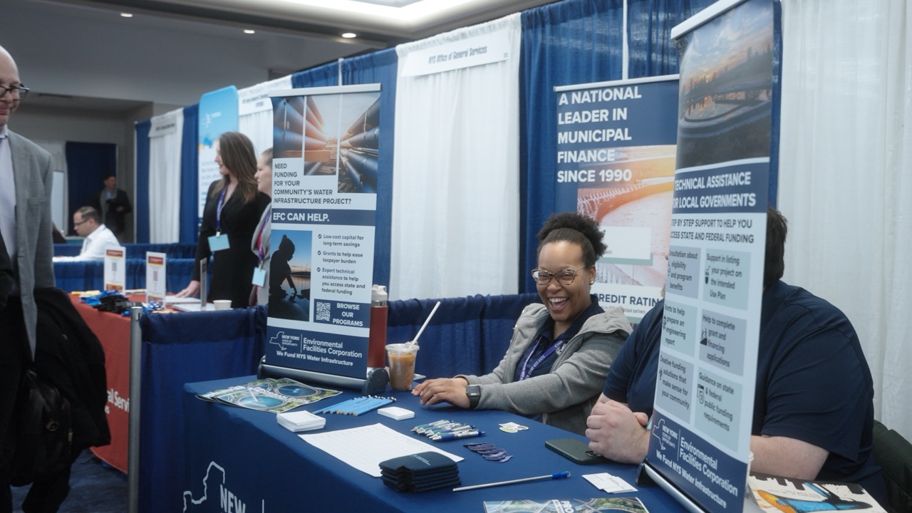 Conference booth with people smiling; sign reads A NATIONAL LEADER IN MUNICIPAL FINANCE SINCE 1990